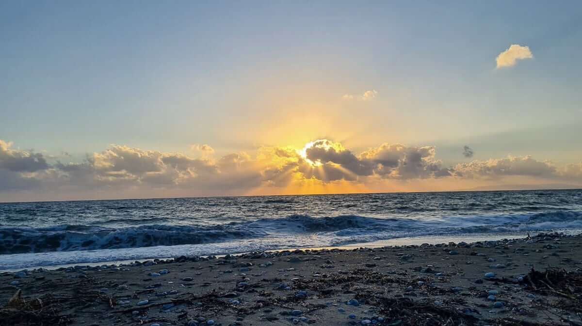 Sunset over the sea in the Mani with waves on the shore