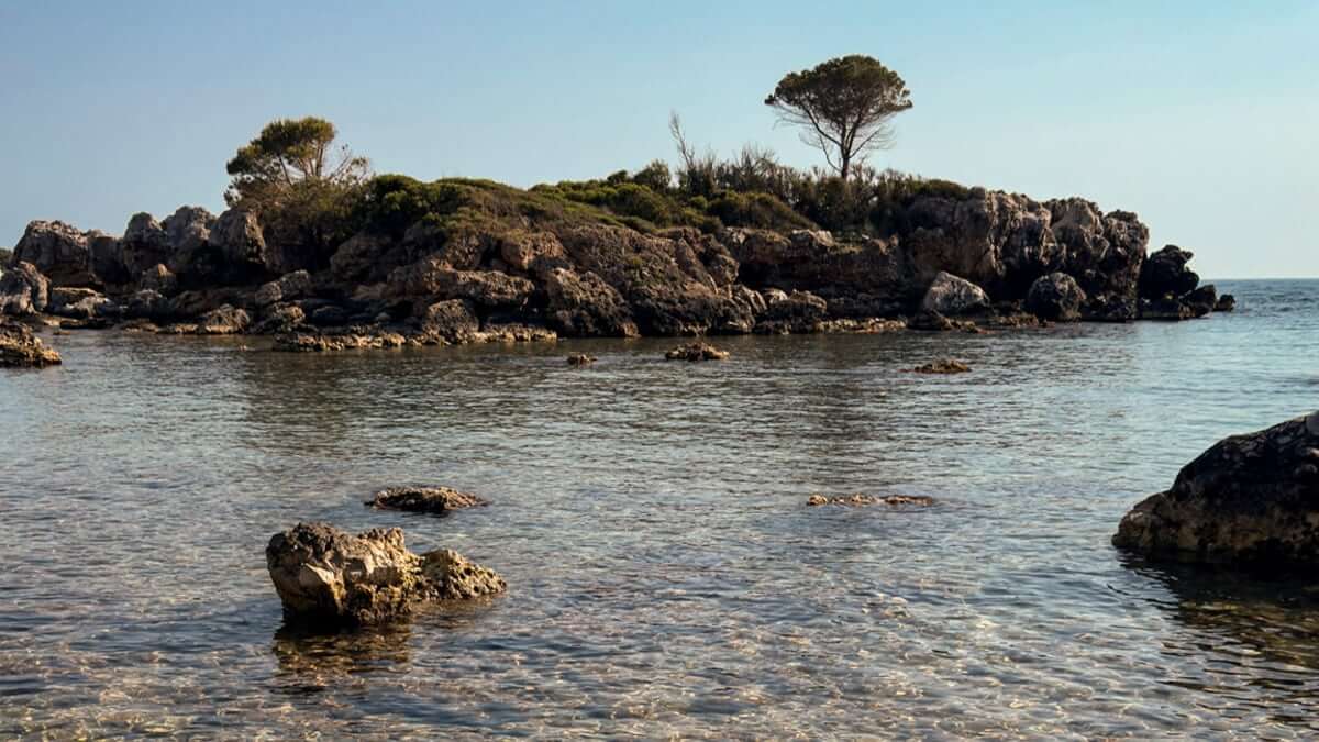 Peaceful rocky islet off the Mani coast with clear seawater