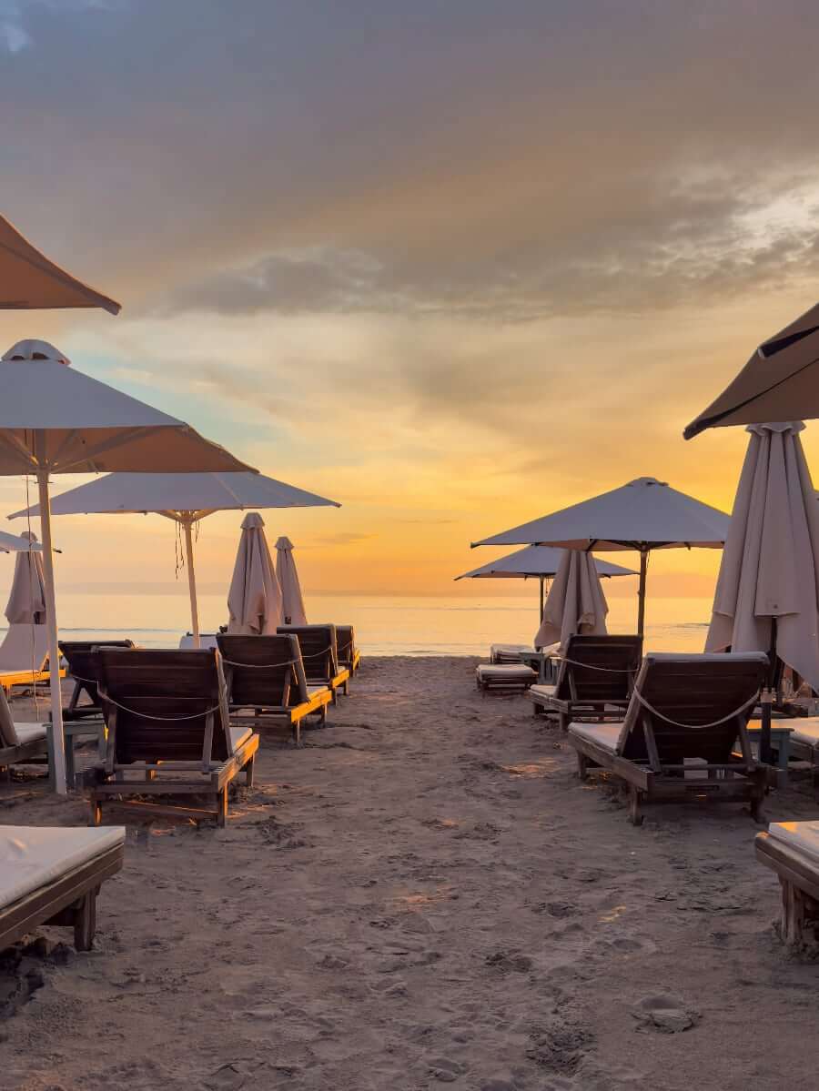 Beach in the Mani at sunset with sun loungers and parasols
